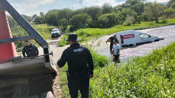 Policías auxilian a conductor arrastrado por la corriente de un rio